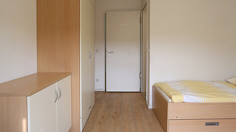 Kleines Schlafzimmer mit Bett und Schrank