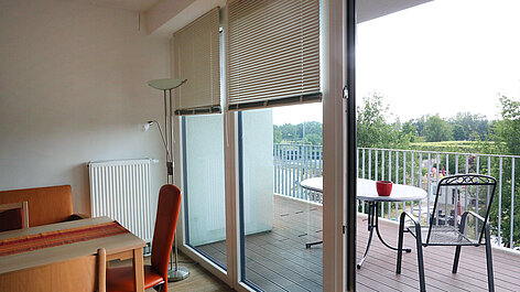 Wohnzimmer mit Balkon und Tisch