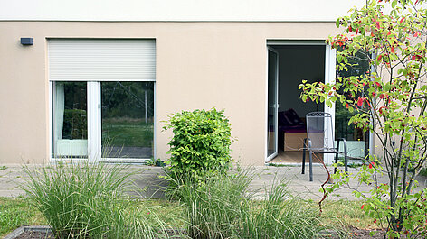 Terrasse mit Gartentür und Sträuchern