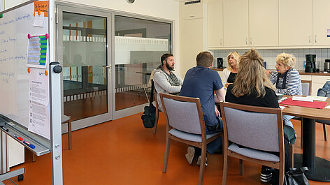 Gruppe diskutiert am Tisch im Büro