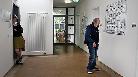 Flur mit Wochenplan und zwei Personen