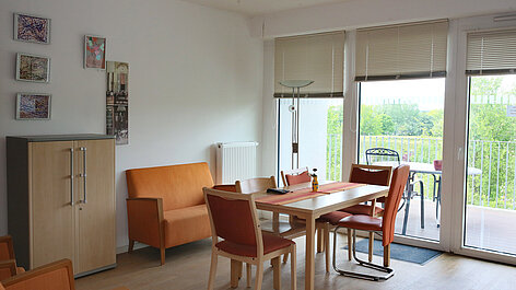 Wohnzimmer mit Esstisch und Balkon